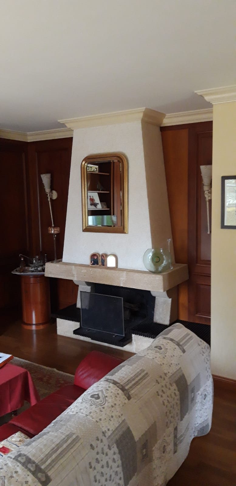 Ancienne cheminée avec hotte enduite et linteau en pierre avant travaux, salon boisé