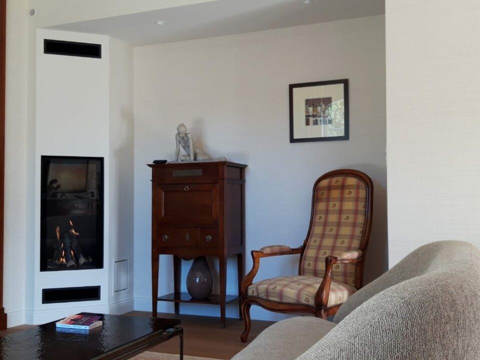 Cheminée moderne avec foyer fermé vertical intégré dans un habillage blanc, salon rénové à Rennes