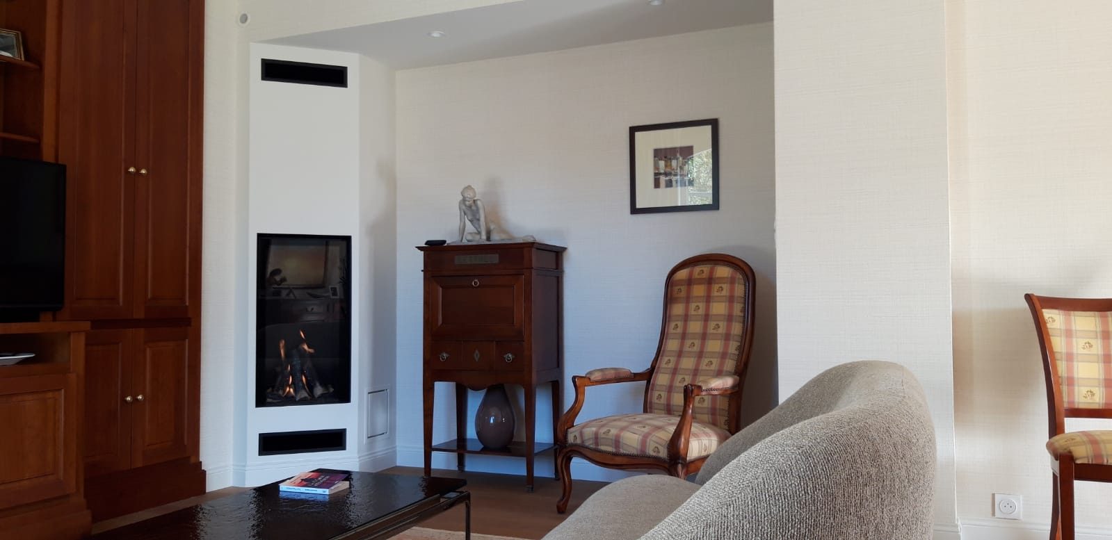 Cheminée moderne avec foyer fermé vertical intégré dans un habillage blanc, salon rénové à Rennes